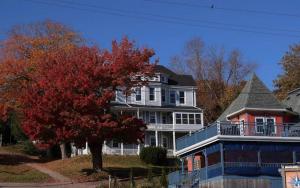a large house with a red tree in front of it at Hillside Landing B&B in Digby
