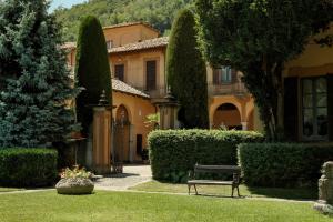 a bench in front of a house with trees at Villa Wirnica Lake Como in Garlate