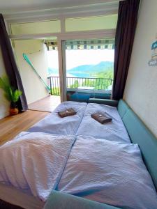 a bed in a room with a large window at MOOKI Sky by Lake in Villach