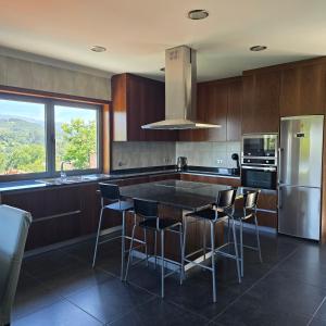 a kitchen with a table and some chairs in it at Casa da Batoca - Rossas in Vieira do Minho