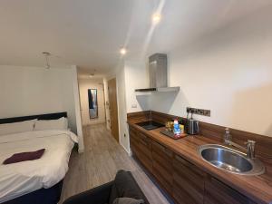 a bathroom with a sink and a bed in it at Central Sheffield Studio for 2 in Sheffield +28 photos