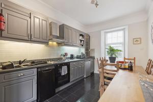 a kitchen with stainless steel appliances and a dining table at Dunella Traditional Cottage in Callander