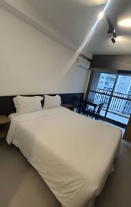 a large white bed in a room with a window at Studio 809 | Luxo e Novo | SP Expo, metrô e Itaú in São Paulo +38 photos