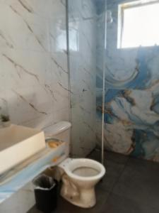 a bathroom with a toilet and a sink at Suites perto praia in Ubatuba