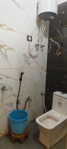 a bathroom with a toilet and a lamp and a bucket at OM DAYAMA Please in Khātu