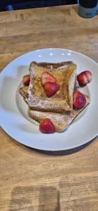 a white plate with two pieces of toast with strawberries at Nandyowa Guesthouse in Kampala