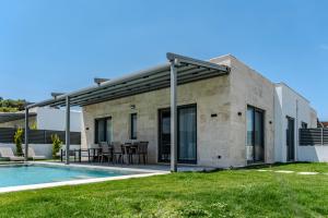 a building with a patio and a swimming pool at Kaura Villas in Milas