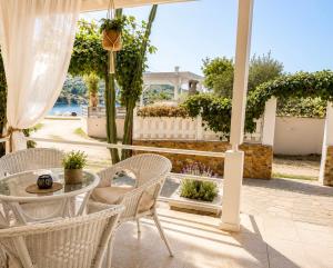 a patio with a table and chairs on a porch at Puerto Porto Koufo in Porto Koufo