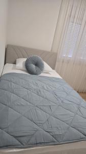 ein Schlafzimmer mit einem Bett mit blauer Bettdecke in der Unterkunft Apartman Anđa in Široki Brijeg