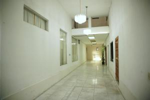 an empty hallway in a building with white walls and windows at Hotel Los Proceres in La Aurora