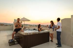 a group of people standing around a hot tub on a roof at Licorne Suites in Tirana