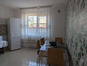 a kitchen with a table and chairs and a window at Cazare Adda Body in Corbu