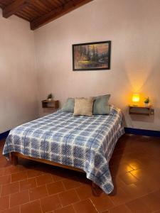 a bedroom with a bed with a blue and white blanket at LA CASA DE DOÑA EMMA in Mazamitla