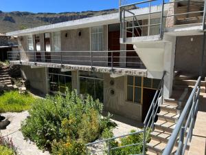a building with a staircase leading up to a balcony at hotel orkkowasi colca in Coporaque