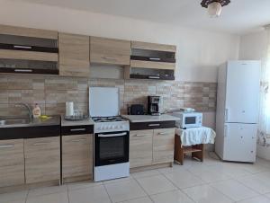 a kitchen with a stove and a white refrigerator at Cazare Adda Body in Corbu