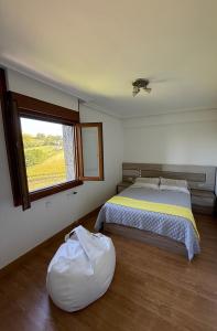 a bedroom with a large bed and a window at Izarra Urdaneta in Aizarna