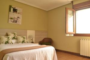 a bedroom with a bed and a window and a chair at Izarra Urdaneta in Aizarna +21 photos