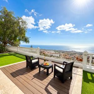 a patio with two chairs and a table on a deck at Villa Tequila in Tijoco de Abajo