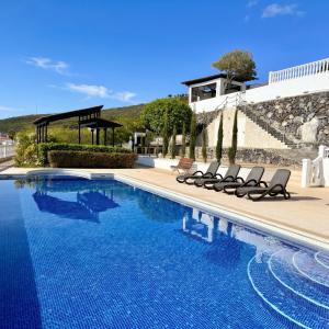 a swimming pool with lounge chairs next to a house at Villa Tequila in Tijoco de Abajo