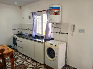 a kitchen with a washing machine and a sink at Depto Manzur in Villa Mercedes
