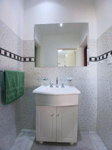 a bathroom with a white sink and a mirror at Depto Manzur in Villa Mercedes +12 photos