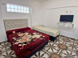 a room with a bed and a couch with flowers on it at Depto Manzur in Villa Mercedes
