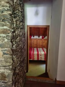 a bedroom with a bed and a stone wall at Chalet Silence - Grand Haury in Auri Grande +17 photos