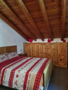 a bedroom with a large bed with wooden ceilings at Chalet Silence - Grand Haury in Auri Grande