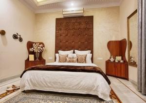 a bedroom with a large bed with a large headboard at Giovanni Suites in Bhopal