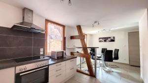 a kitchen with a sink and a stove top oven at Le Zen in Eguisheim +3 photos