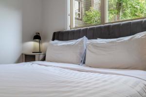 a white bed with white pillows and a window at The Beach Point - Ground Floor BBQ in Invermere