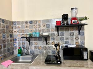 a kitchen counter with a sink and a microwave at Estudio #4 a 5 min del malecon in La Paz +21 photos