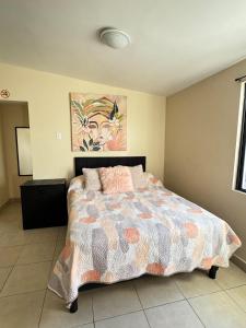 a bedroom with a bed and a painting on the wall at Estudio #4 a 5 min del malecon in La Paz
