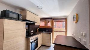 a kitchen with wooden cabinets and a black counter top at Le Nature in Eguisheim