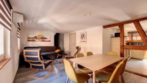 a dining room and living room with a table and chairs at Le Nature in Eguisheim