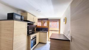 a kitchen with wooden cabinets and a stove top oven at Le Nature in Eguisheim +2 photos