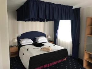 a bedroom with a bed with a blue headboard and a window at Polar Hotel Oteren in Oteren