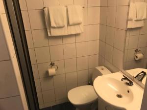 a white bathroom with a toilet and a sink at Polar Hotel Oteren in Oteren +9 photos