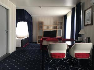a hotel room with a table and chairs and a bed at Polar Hotel Oteren in Oteren