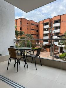 a balcony with a table and chairs and a view of a building at Torre Ginebra luxury laureles in Medellín
