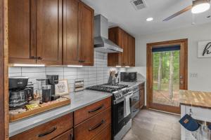 a kitchen with wooden cabinets and a stove top oven at Jackson’s Urban Cabin Escape in Jackson