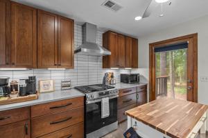 a kitchen with wooden cabinets and a stove top oven at Jackson’s Urban Cabin Escape in Jackson