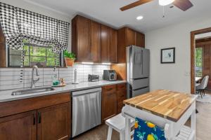 a kitchen with wooden cabinets and a stainless steel refrigerator at Jackson’s Urban Cabin Escape in Jackson