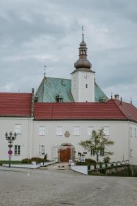 a large white building with a red roof at Penzion Pod Kašnou in Frýdek-Místek