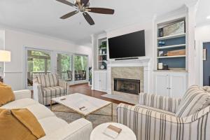 a living room with a fireplace and a flat screen tv at 1005 Crooked Oak Lane in Seabrook Island