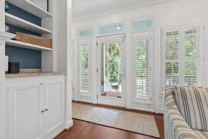 a kitchen with white cabinets and windows and a couch at 1005 Crooked Oak Lane in Seabrook Island