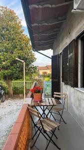 a patio with two chairs and a table with flowers at Casa Irene in Marina di Massa