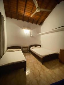 a room with two beds and a ceiling at CFR SkyLine in Katunayaka +4 photos