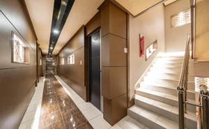 a hallway of a building with stairs and a door at 호텔 휴 in Pup'yŏng-yŏk