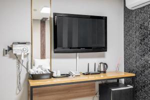 a television on top of a wooden table with a camera at 호텔 휴 in Pup'yŏng-yŏk